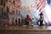 In this April 25, 2019 photo, Cuban migrant Danil Hernandez, right, prepares to serve up traditional Cuban food to customers at Little Habana restaurant in Ciudad Juarez, Mexico. Hernandez arrived earlier in April at Mexico's northern border and is waiting his turn to request asylum in the U.S. (AP Photo/Christian Torres)