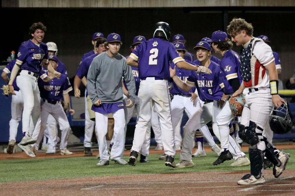 John Jay teammates welcome Nick Fassert as he crosses home plate during the Panas vs. John Jay Cross River Section One Class A baseball championships at Purchase College in Purchase, New York, Mat 27, 2023. John Jay beat Panas 4-0, to force the championship game to be played on Sunday. 