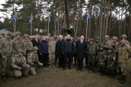 Polish Defence Minister Antoni Macierewicz (R) and President Andrzej Duda pose for a picture with soldiers after the welcoming ceremony for U.S.-led NATO troops at polygon near Orzysz, Poland, April 13, 2017. REUTERS/Kacper Pempel