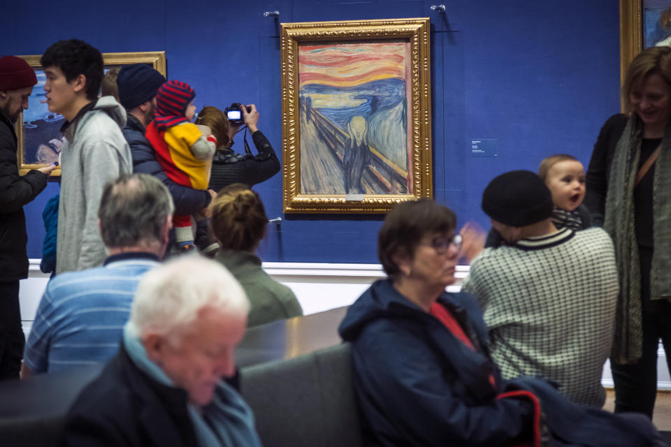 FILE - People look at Edvard Munch's "The Scream" at the National Gallery in Oslo, Norway, Sunday Jan. 13, 2019. On Friday, Nov. 11, 2022, activists from the organization ''Stopp oljeletinga'' (Stop Oil Exploration) tried to glue themselves to the frame of the painting. (Heiko Junge/NTB Scanpix via AP, file)