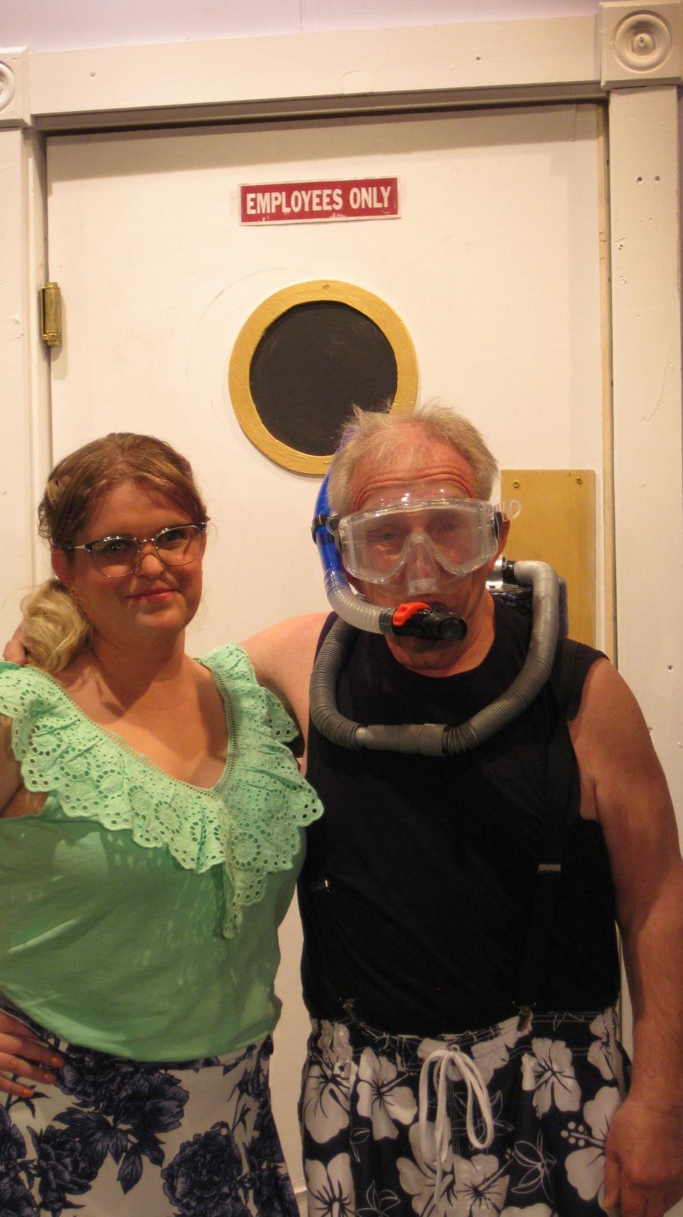 Meg Sullivan as Candy the receptionist, left, confers with Tom Pucci as Wilberforce “Bubba” Brown, who runs a variety of “extracurricular” enterprises within the Lovers Landing Beach Hotel.