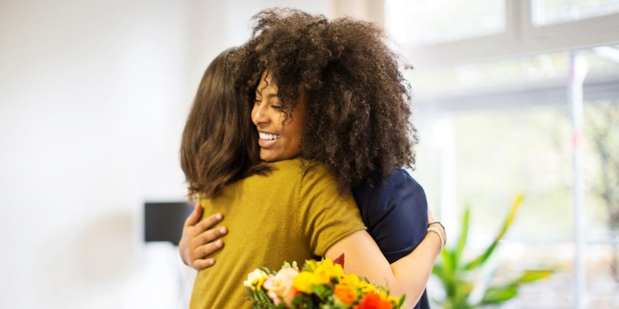 woman congratulating female coworker over her success