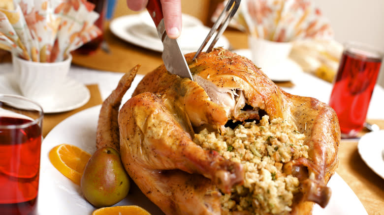 person cutting turkey with stuffing