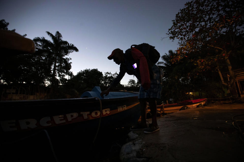 White River Fish Sanctuary warden Lipton Bailey prepares to head out on a patrol in White River, Jamaica, Tuesday, Feb. 12, 2019. "We are looking for violators," Bailey said. "Sometimes you find spearmen. They think they're smart. We try to beat them at their game." (AP Photo/David Goldman)