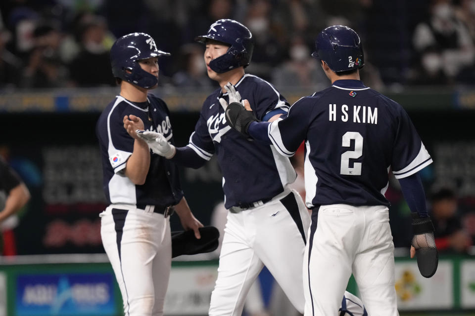 South Korea's Park Kun-woo celebrates with South Korea's Kim Hyseong, right, and Park Have-min after hitting a grand slam during the fourth inning of the first round Pool B game between the South Korea and China at the World Baseball Classic (WBC) at Tokyo Dome in Tokyo, Japan, Monday, March 13, 2023. (AP Photo/Eugene Hoshiko)