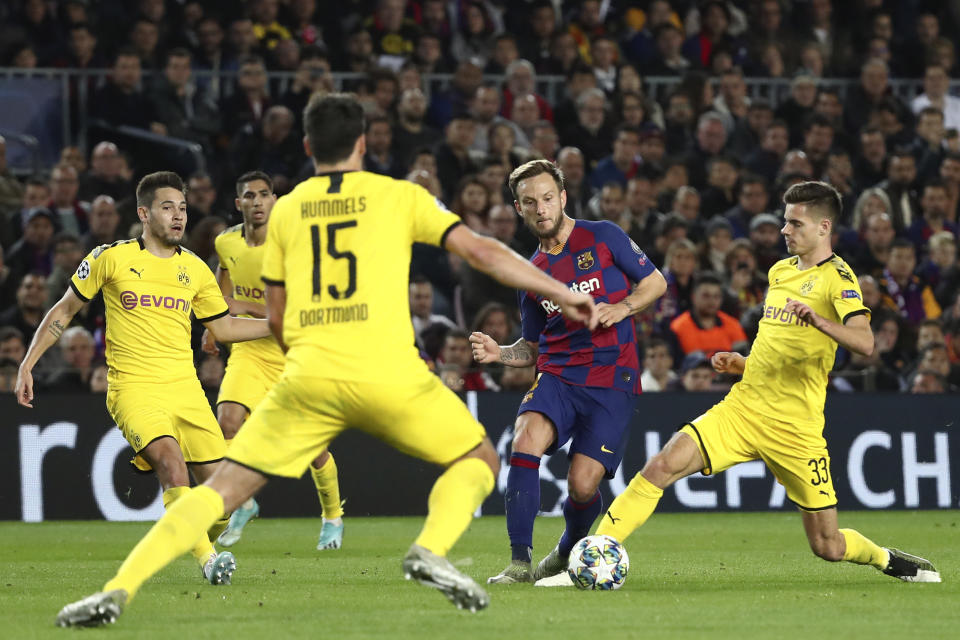 El volante croata Ivan Rakitic, segundo de derecha a izquierda, del Barcelona, se abre paso entre jugadores del Dortmund, en un duelo por el Grupo F de la Liga de Campeones en el Camp Nou de Barcelona, el miércoles 27 de noviembre de 2019. (AP Foto/Emilio Morenatti)