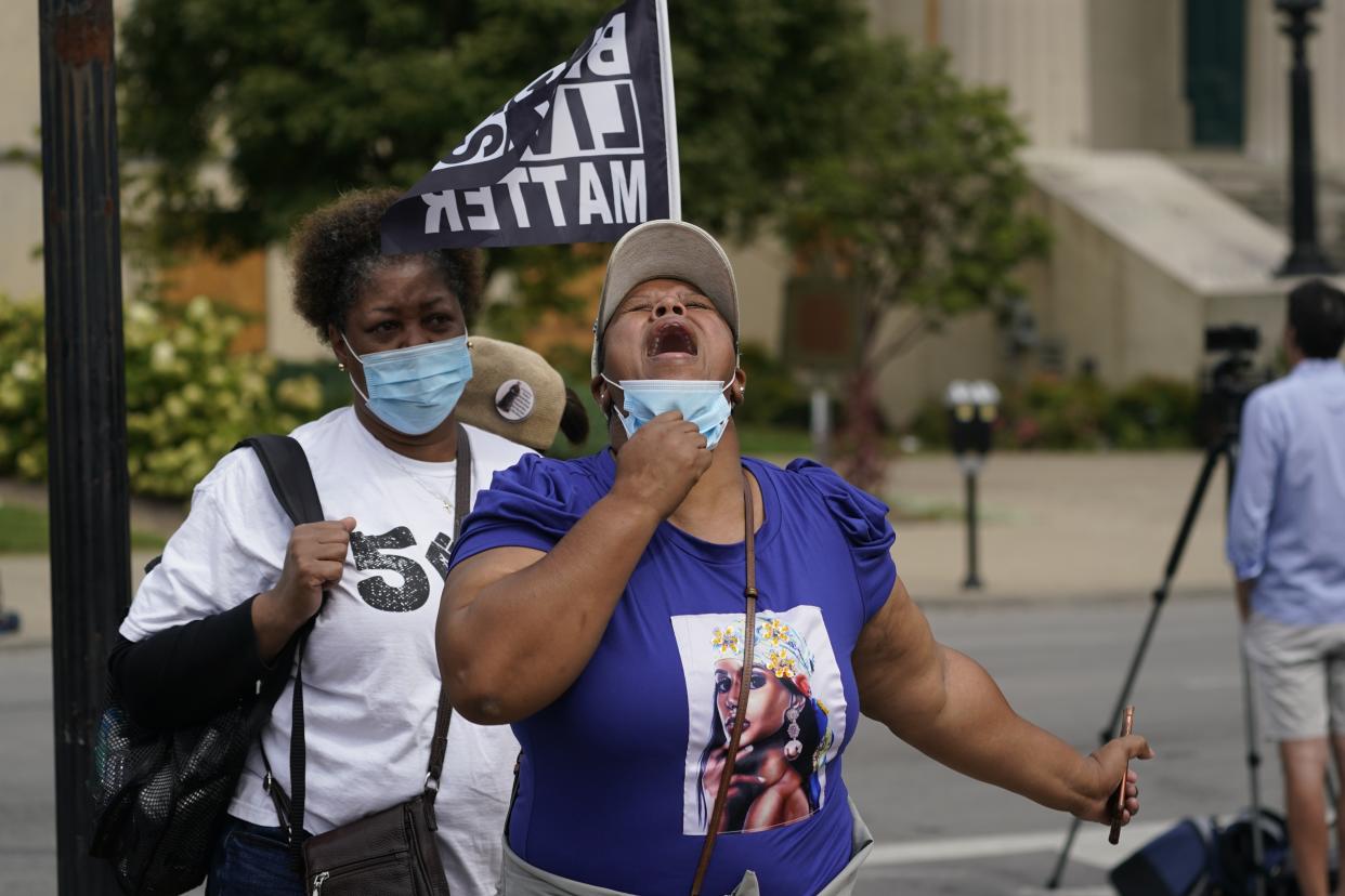 A woman reacts to news in the Breonna Taylor shooting