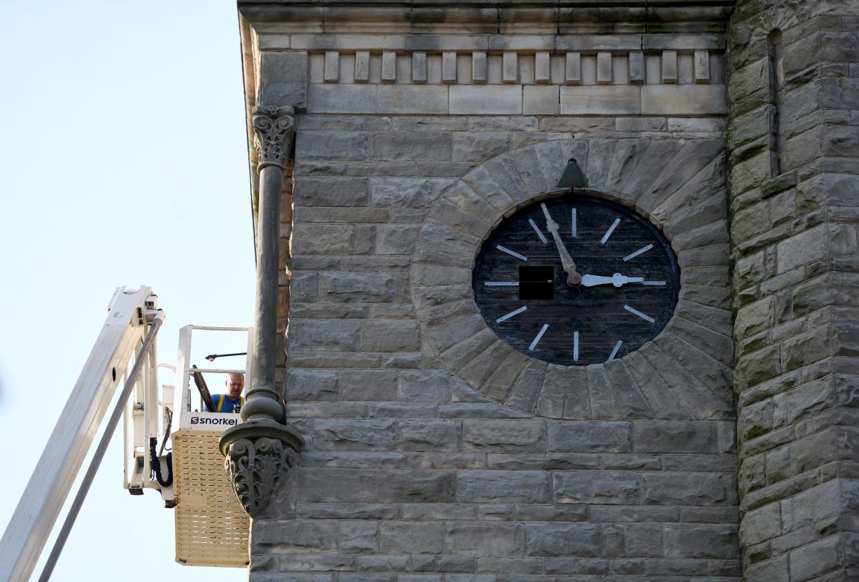 Workers change out the iconic town clock at First United Methodist Church in Massillon. The clock has watched over downtown since the 1800s.