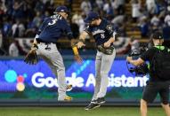 Oct 15, 2018; Los Angeles, CA, USA; Milwaukee Brewers shortstop Orlando Arcia (3) and left fielder Ryan Braun (8) celebrate after defeating the Los Angeles Dodgers in game three of the 2018 NLCS playoff baseball series at Dodger Stadium. Mandatory Credit: Richard Mackson-USA TODAY Sports