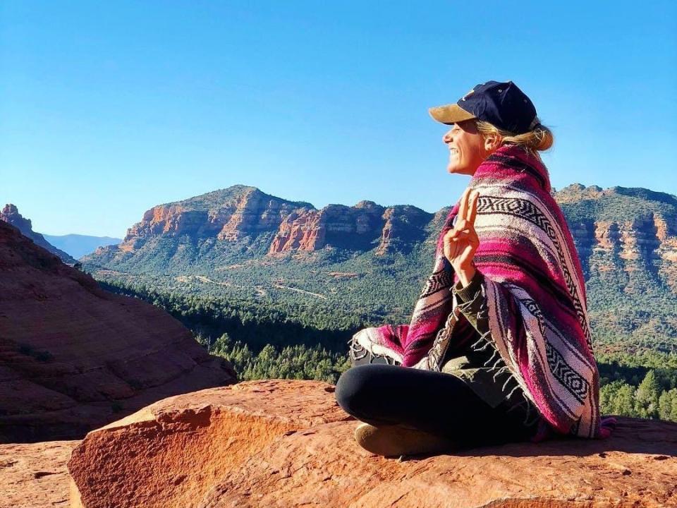 the writer sitting on red rocks