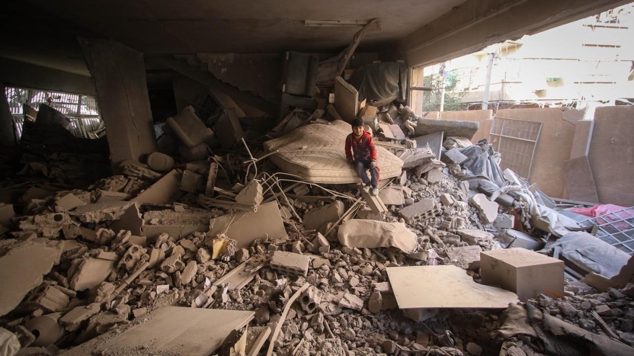 Ein Kind sitzt nach einem Luftangriff auf Duma in Ost-Ghuta nahe der syrischen Hauptstadt Damaskus auf einem Trümmerhaufen. Foto: Muhmmad Al-Najjar/SOPA Images via ZUMA Wire