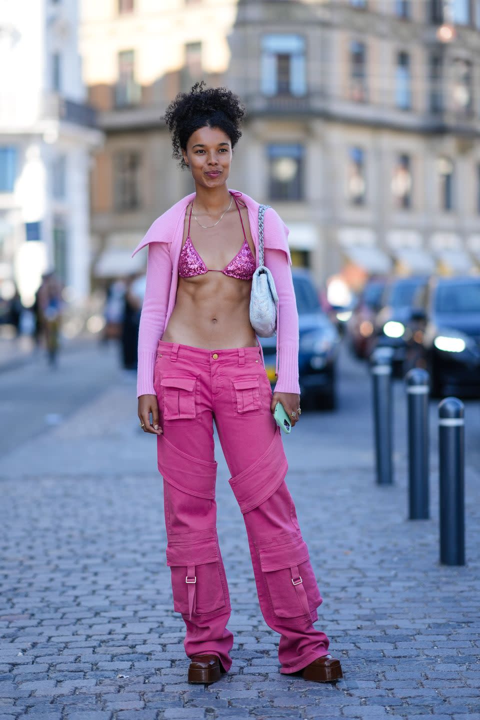 copenhagen, denmark august 11 a guest wears a pale pink wool high neck ribbed cardigan, a pink shiny sequined bra swimwear, a pale blue fluffy shoulder bag, pink wide legs cargo pants, dark brown shiny leather ankle boots, gold rings, outside saks potts during copenhagen fashion week springsummer 2023, on august 11, 2022 in copenhagen, denmark photo by edward berthelotgetty images