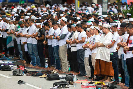 People pray before an Anti-ICERD (International Convention on the Elimination of All Forms of Racial Discrimination) mass rally in Kuala Lumpur, Malaysia, December 8, 2018. REUTERS/Sadiq Asyraf