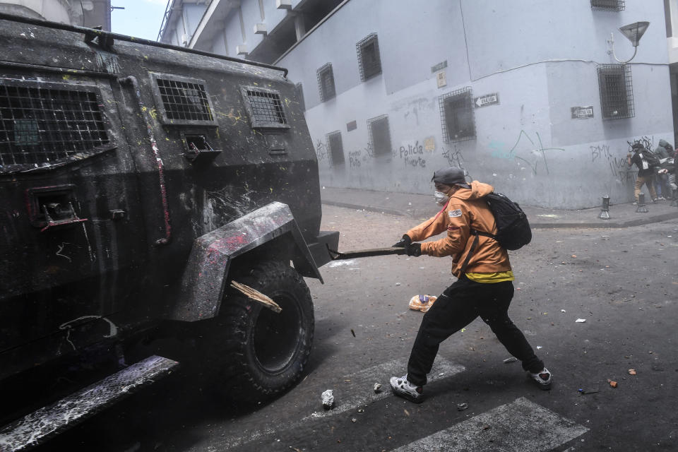 A demonstrator hits a riot police vehicle with a stick during clashes in Quito, as thousands march against Ecuadorean President Lenin Moreno's decision to slash fuel subsidies, on Oct. 9, 2019. (Photo: Martin Bernetti/AFP via Getty Images)