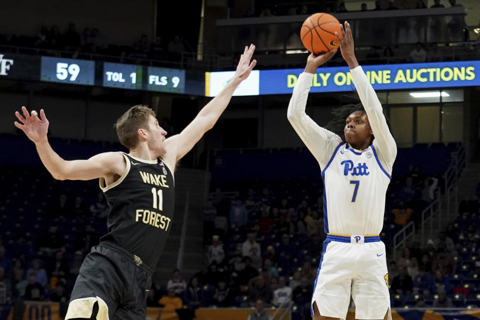 Pittsburgh guard Carlton Carrington (7) puts a shot up as Wake Forest forward Andrew Carr (11) defends during the second half of an NCAA college basketball game Wednesday, Jan. 31, 2024, in Pittsburgh. (AP Photo/Matt Freed)