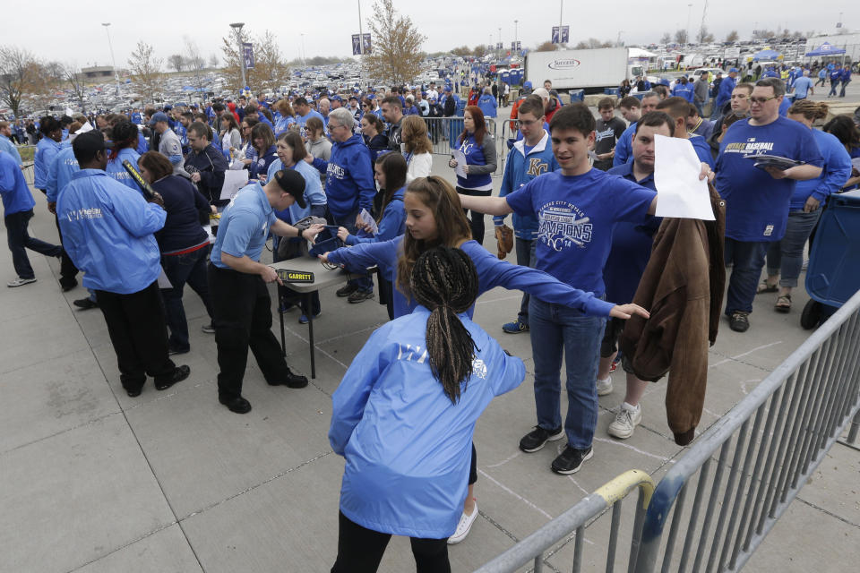 FILE - In this April 6, 2015, file photo, security wands fans before an opening day baseball game between the Chicago White Sox and Kansas City Royals at Kauffman Stadium in Kansas City, Mo. The metal detectors that greet sports fans at the gates might soon be accompanied by thermal body scanners, in the gargantuan task of better protecting venues from virus spread in order to bring the games back for in-person viewing. (AP Photo/Orlin Wagner, File)