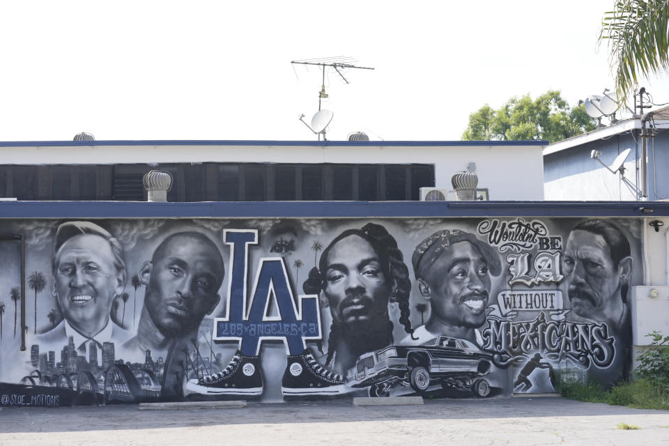 A portion of a mural by artist sloe_motions depicting Vin Scully, Kobe Bryant, Snoop Dogg, Tupac Shakur and Danny Trejo is seen on the side of Speedy Auto Tint on Friday, Sept. 29, 2023, in Bellflower, Calif. (AP Photo/Chris Pizzello)