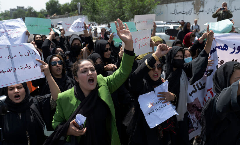 Afghan women hold placards as they march and shout slogans “Bread, work, freedom” during a womens’ rights protest in Kabul on August 13, 2022. – Taliban fighters beat women protesters and fired into the air on Saturday as they violently dispersed a rare rally in the Afghan capital, days ahead of the first anniversary of the hardline Islamists’ return to power. (Wakil Kohsar/AFP; Getty Images)