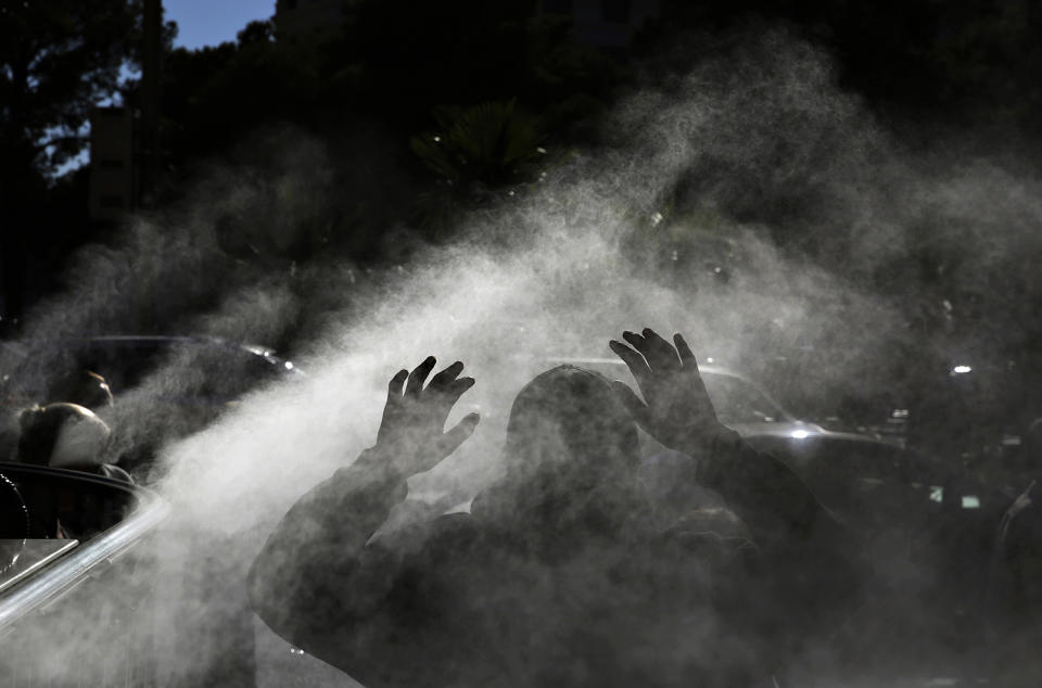 <p>A man walks through a mister during the start of a heat wave in Las Vegas, June 16, 2017. (John Locher/AP) </p>