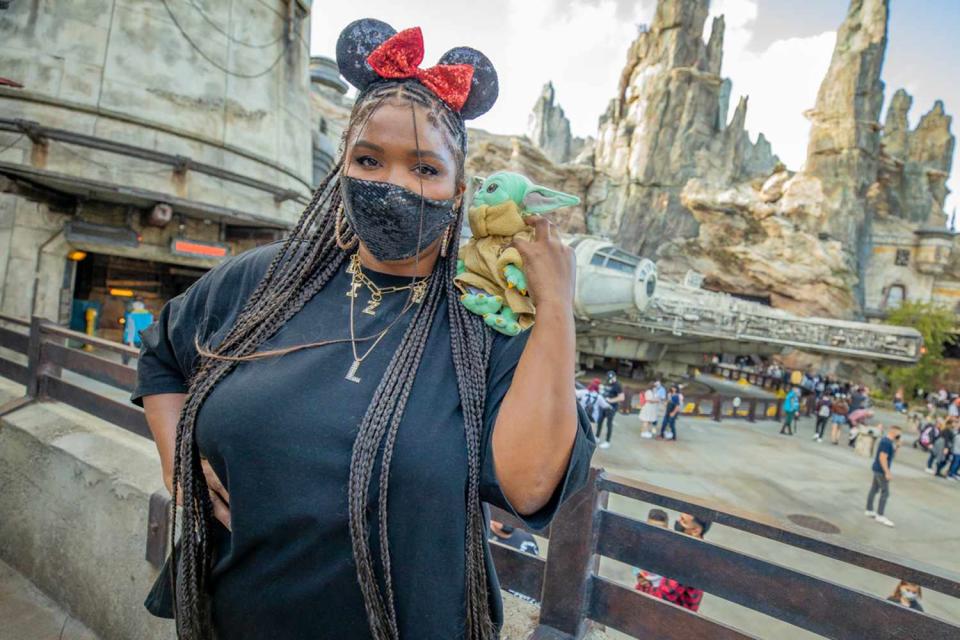 <p>Forget an angel or a devil — this Grammy-winning singer had a Baby Yoda on her shoulder on a recent trip to Disneyland in California! The star spent the day at <em>Star Wars</em>: Galaxy's Edge, and is pictured here in front of the Millennium Falcon donning sequined Minnie Mouse ears!</p>