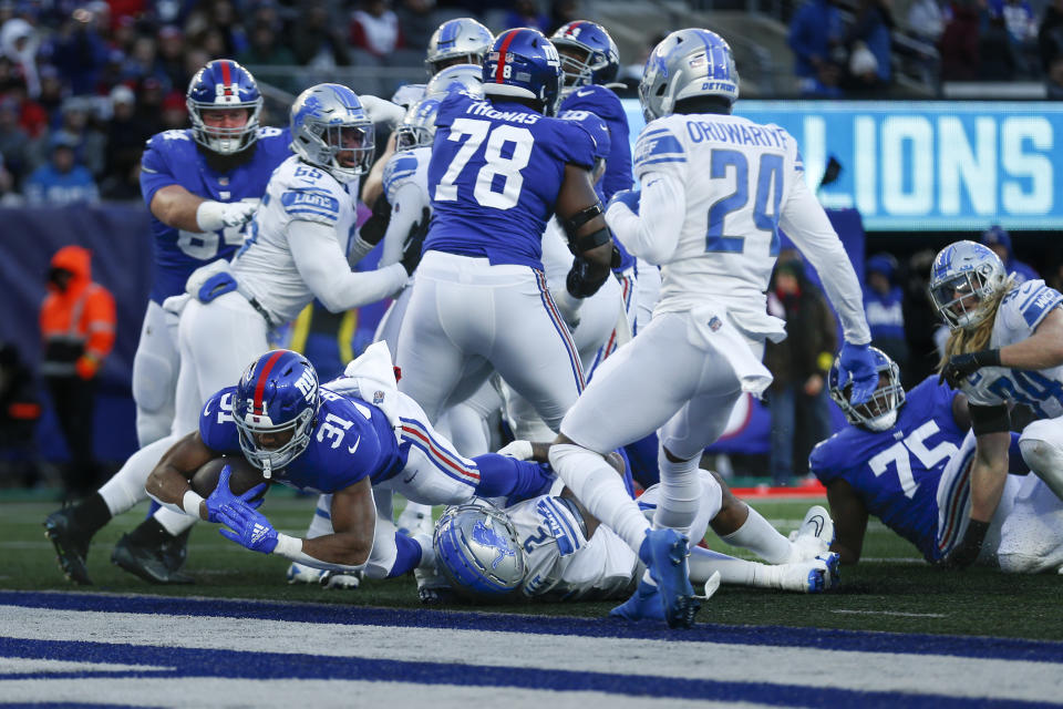 New York Giants running back Matt Breida (31) dives in for a touchdown against Detroit Lions linebacker Austin Bryant (2) during the second half of an NFL football game, Sunday, Nov. 20, 2022, in East Rutherford, N.J. (AP Photo/John Munson)