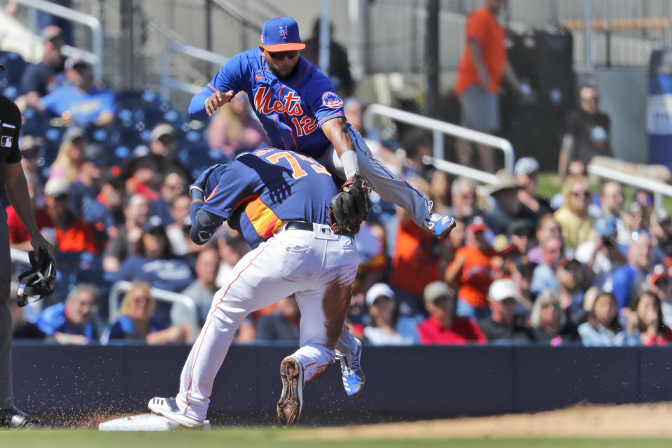 Houston Astros' Taylor Jones (79) and New York Mets third baseman Eduardo Nunez (12) collide as Nunez reaches for the throw on a triple by Jones during the second inning of a spring training baseball game Saturday, Feb. 29, 2020, in West Palm Beach, Fla. (AP Photo/Jeff Roberson)