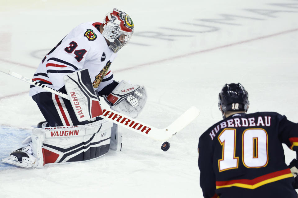 Chicago Blackhawks goalie Petr Mrazek makes a save as Calgary Flames' Jonathan Huberdeau looks for a rebound during the first period of an NHL hockey game Saturday, Jan. 27, 2024, in Calgary, Alberta. (Larry MacDougal/The Canadian Press via AP)