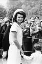 <p>Jackie Kennedy holds hands with her son, John F Kennedy Jr, as they attend the inauguration of a memorial to the late John F. Kennedy. The picture was taken in Runnymede, Surrey, nearly eighteen months after his assassination. </p>