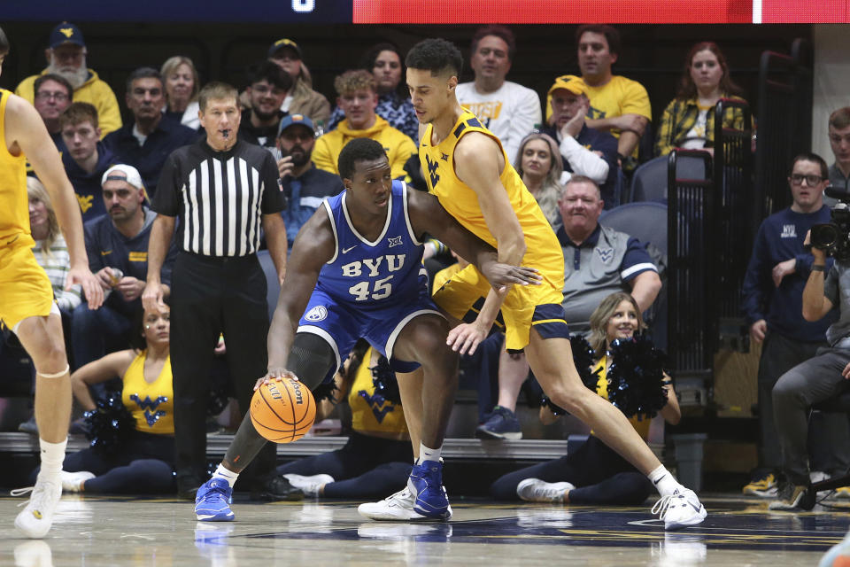 BYU forward Fousseyni Traore (45) is defended by West Virginia center Jesse Edwards, right, during the second half of an NCAA college basketball game Saturday, Feb. 3, 2024, in Morgantown, W.Va. (AP Photo/Kathleen Batten)