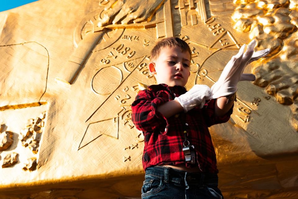 Jack Foxley Strasser, 4, puts on white gloves so he can touch the Golden Spike Monument after its arrival in front of the Utah state Capitol in Salt Lake City on Monday, Oct. 23, 2023. The 43-foot-tall golden spike was commissioned as a public art piece by the Golden Spike Foundation to honor the tens of thousands of railroad workers who built the transcontinental railroad. | Megan Nielsen, Deseret News