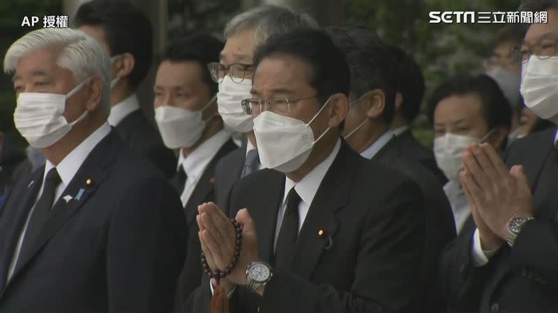 靈車開往首相官邸並開進官邸內，首相岸田文雄率內閣人員一同向安倍鞠躬合掌。（圖／AP授權）