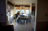 Natalie Abbas sits at her dining room table, her "Command Post," in Myersville, Md., Tuesday, Jan. 19, 2021, the day before the presidential inauguration. As a member of Braver Angels, Abbas, who believes the election was stolen, meets regularly with a neighbor who cheers Biden as the rightful winner, to ponder the greatest challenge facing Biden and American society: how can they find common ground if they no longer exist in the same reality? (AP Photo/Cliff Owen)