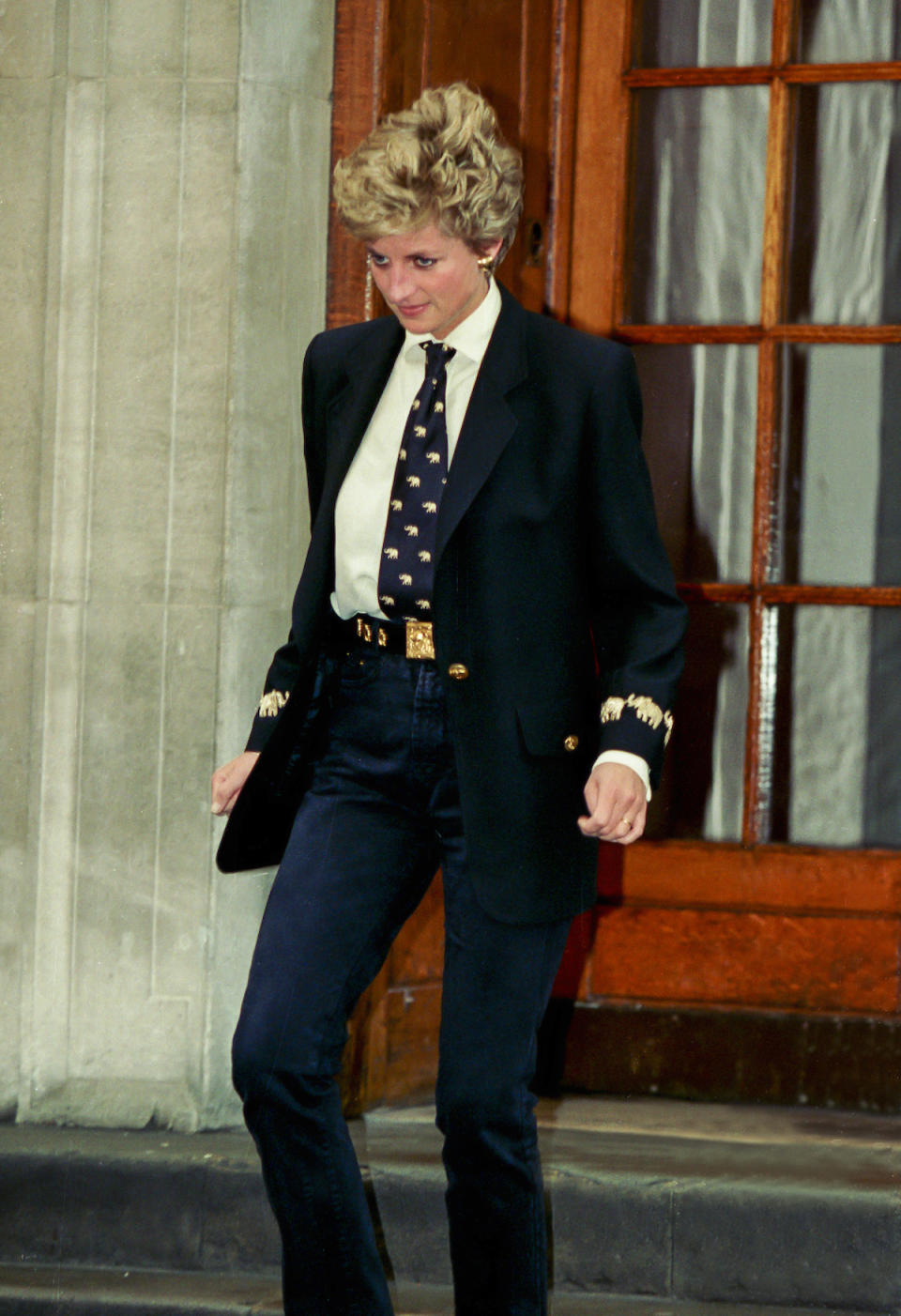 <p>Later in her life, Diana embraced a more chic verson of androgyny, pairing a tie with a gold-embellished jacket and fitted pants. (Photo: Julian Parker/UK Press via Getty Images) </p>