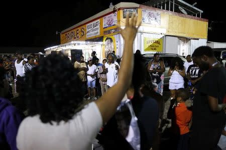 Community members gather during a vigil at the Triple S Food Mart after the U.S. Justice Department announced they will not charge two police officers in the 2016 fatal shooting of Alton Sterling, in Baton Rouge, Louisiana, U.S., May 2, 2017. REUTERS/Jonathan Bachman