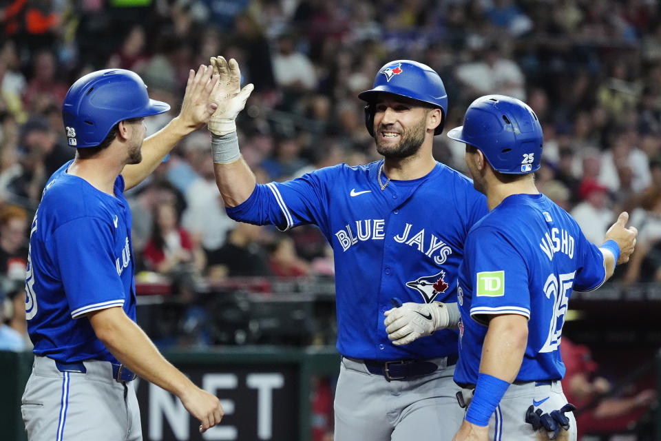 Toronto Blue Jays' Kevin Kiermaier, center, celebrates his grand slam against the Arizona Diamondbacks with Blue Jays' Ernie Clement (28) and Daulton Varsho (25) during the fourth inning of a baseball game, Sunday, July 14, 2024, in Phoenix. (AP Photo/Ross D. Franklin)