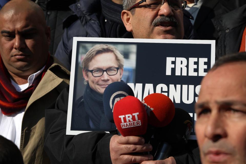 FILE - In this Monday, Dec. 23, 2013 file photo, a Turkish journalist holds a placard with a photo of Magnus Falkehed, a Swedish correspondent based in Paris, who was abducted in Syria in November 2013 by armed Syrian opposition groups, during a protest in Ankara, Turkey. On Wednesday, Jan. 8, 2014, Sweden's Foreign Ministry confirmed the release of writer Magnus Falkehed and photographer Niclas Hammarstrom, and said both were receiving assistance from Swedish diplomats in Beirut. (AP Photo/Burhan Ozbilici, File)