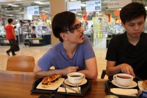 Chatty man next to unhappy looking man at breakfast table