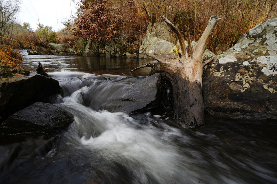 Ash Swamp Brook flows a few hundred yards behind the Stearns Park trailer residences, Wednesday, Nov. 15, 2023, in Hinsdale, N.H. Longtime resident Geoffrey Holt often enjoyed solitude alongside the brook. (AP Photo/Robert F. Bukaty)