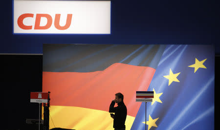 A worker passes a logo sign before a party meeting of the German conservative Christian Democratic Union (CDU) party meeting in Leipzig November 13, 2011. REUTERS/Tobias Schwarz/Files