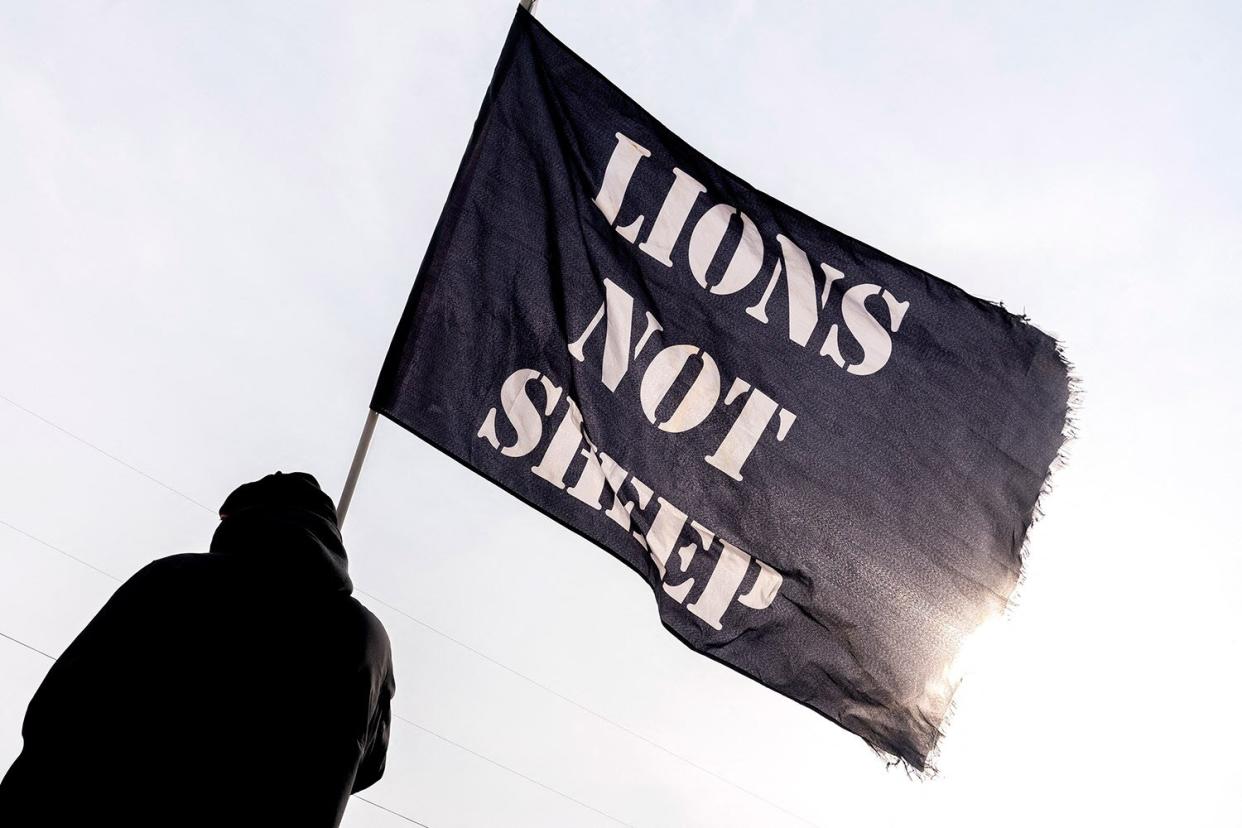 A supporter carries a Lions Not Sheep flag as the Peoples Convoy gathers at the Hagerstown Speedway in Hagerstown, Maryland