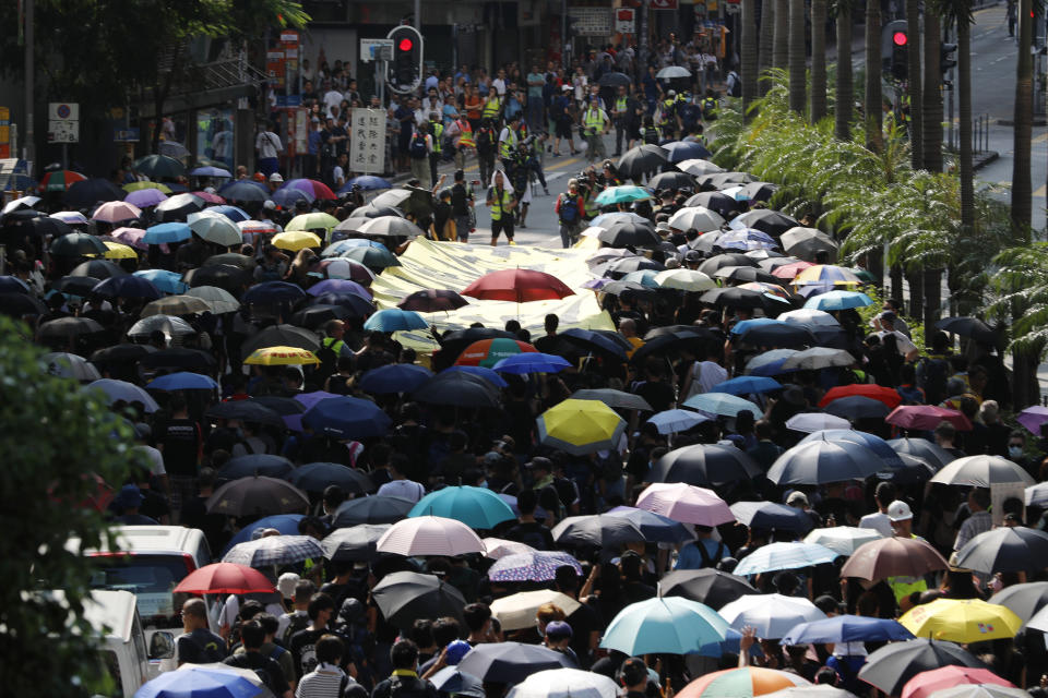 Protesters march with umbrellas in Hong Kong on Saturday, Oct. 5, 2019. All subway and trains services are closed in Hong Kong after another night of rampaging violence that a new ban on face masks failed to quell. (AP Photo/Vincent Thian)