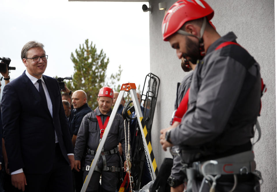 Serbian president Aleksandar Vucic, left, inspects the search and rescue team members during his visit to the Gazivode Dam near the village of Gazivode, Kosovo on Saturday, Sept. 8, 2018. Vucic is on a two day visit to Kosovo. (AP Photo/Visar Kryeziu)