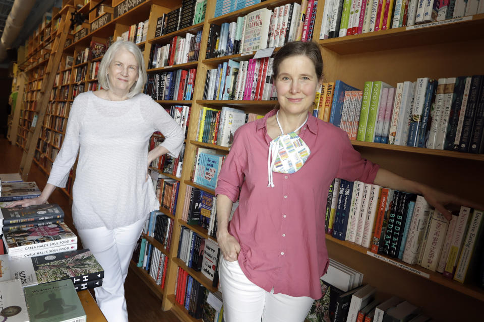 In this Thursday, June 25, 2020, photo, novelist Ann Patchett, right, and her business partner, Karen Hayes, left, pose in their independent bookstore, Parnassus Books, in Nashville, Tenn. Their bookstore that opened and thrived while others were closing their doors is once again defying the odds during the coronavirus pandemic. (AP Photo/Mark Humphrey)