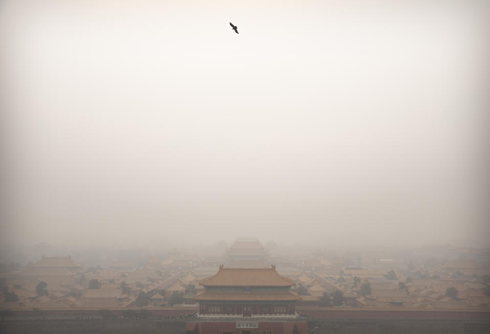 FILE - In this Jan. 18, 2020, file photo, a bird flies over the Forbidden City on a day with high levels of air pollution in Beijing. China's Premier Li Keqiang announced that the country would target a reduction of 18% in carbon intensity over the course of the next five years as part of the meeting of the ceremonial legislature which kicked off its annual meeting Friday, March 5, 2021. (AP Photo/Mark Schiefelbein, File)