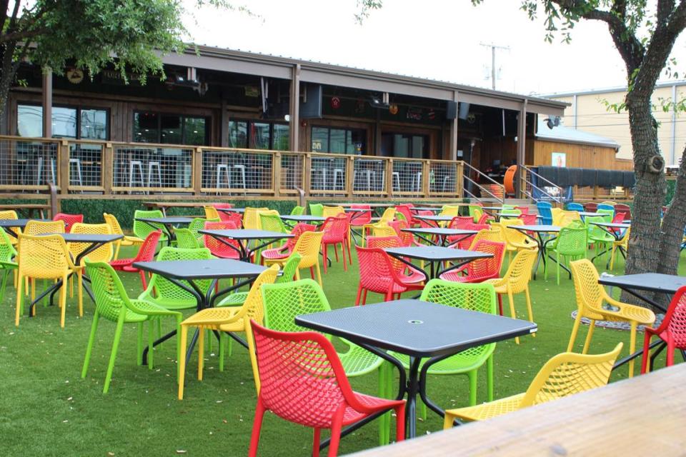 Outdoor lawn patio at Little Woodrow’s is full of colorful chairs and lawn games along with a 400-inch television screen.