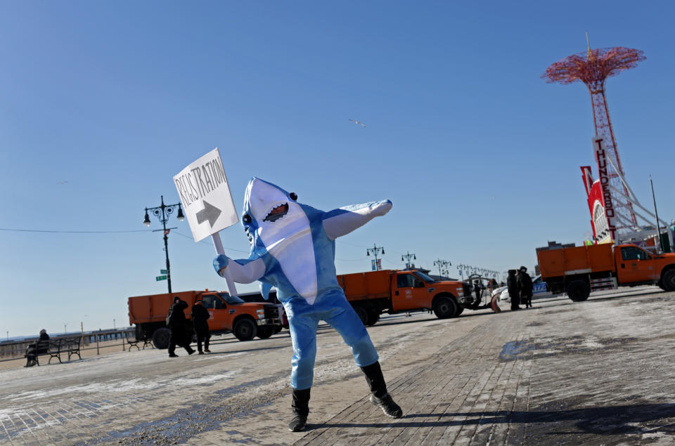 <p>A person in a shark costume directs Polar Bear Club swimmers before their annual icy plunge into the Atlantic Ocean on New Year’s Day, January 1, 2018, at Coney Island in the Brooklyn borough of New York City. (Photo: Yana Paskova/Getty Images) </p>