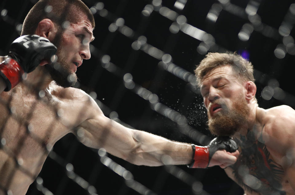 Khabib Nurmagomedov, left, punches Conor McGregor during a lightweight title mixed martial arts bout at UFC 229 in Las Vegas, Saturday, Oct. 6, 2018. (AP Photo/John Locher)