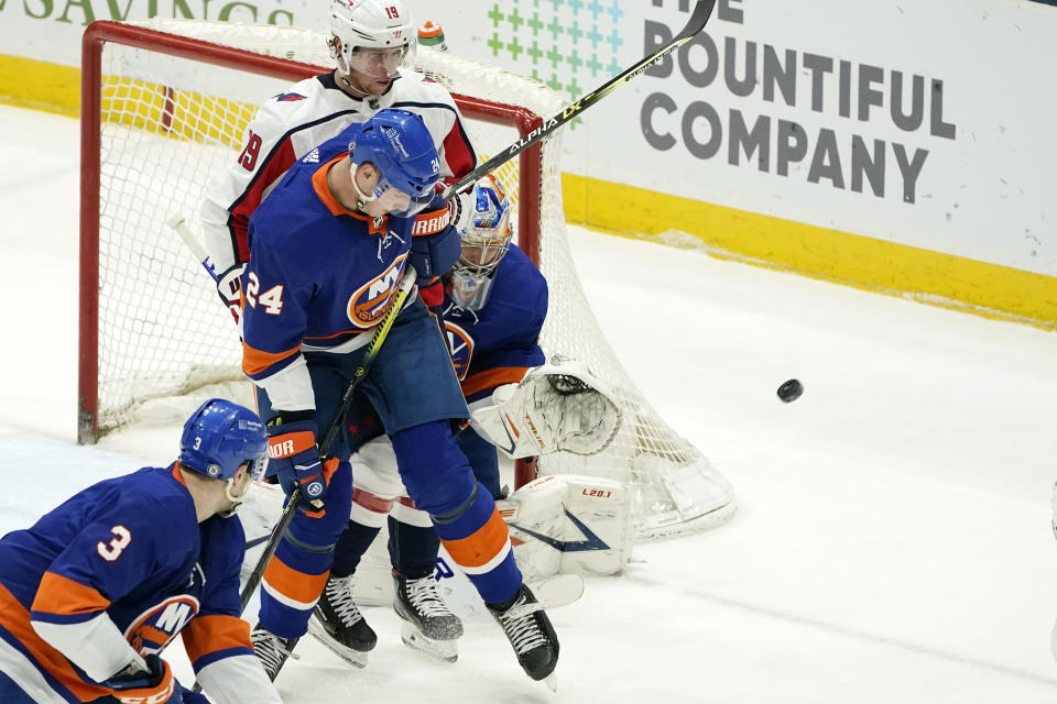 New York Islanders' Scott Mayfield (24) defends against Washington Capitals center Nicklas Backstrom (19) as Islanders goaltender Semyon Varlamov (40) makes a save during the second period of an NHL hockey game Thursday, April 22, 2021, in Uniondale, N.Y. (AP Photo/Kathy Willens)