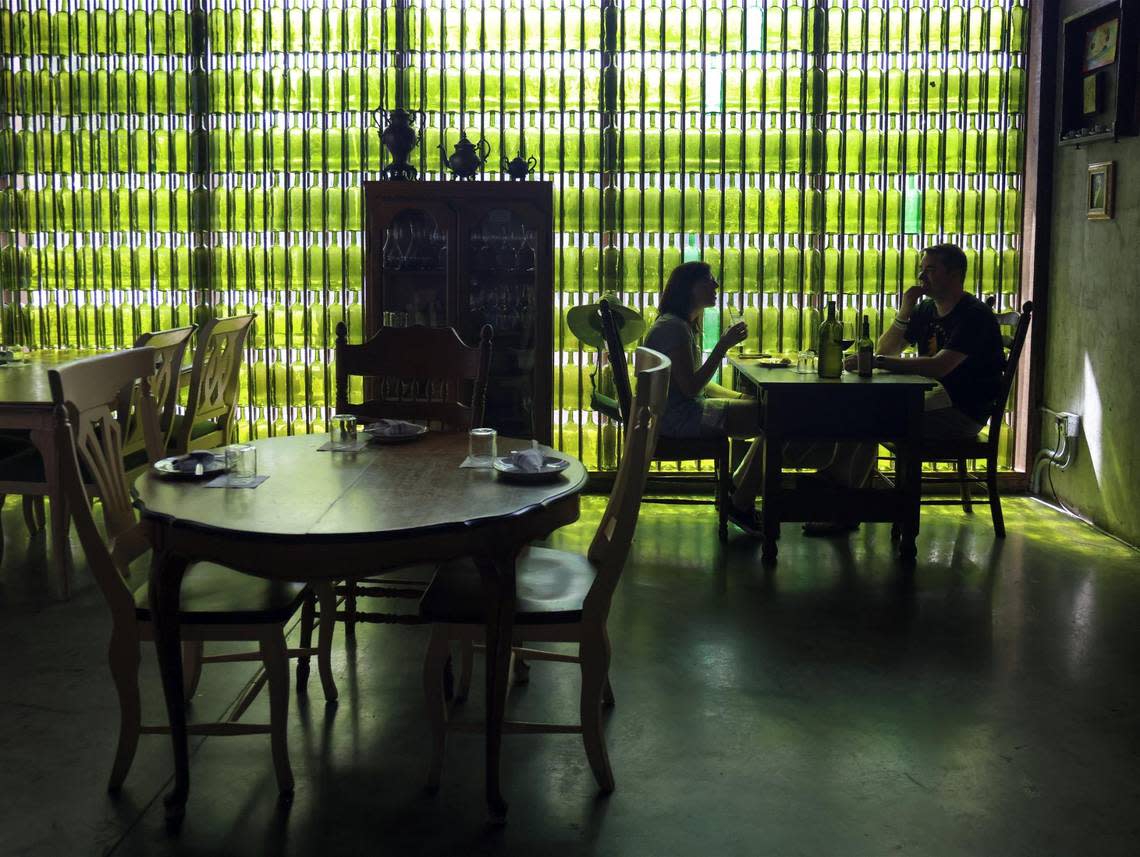 Customers enjoy lunch against the backdrop of green glass bottles collected by the owners at Bunbury.