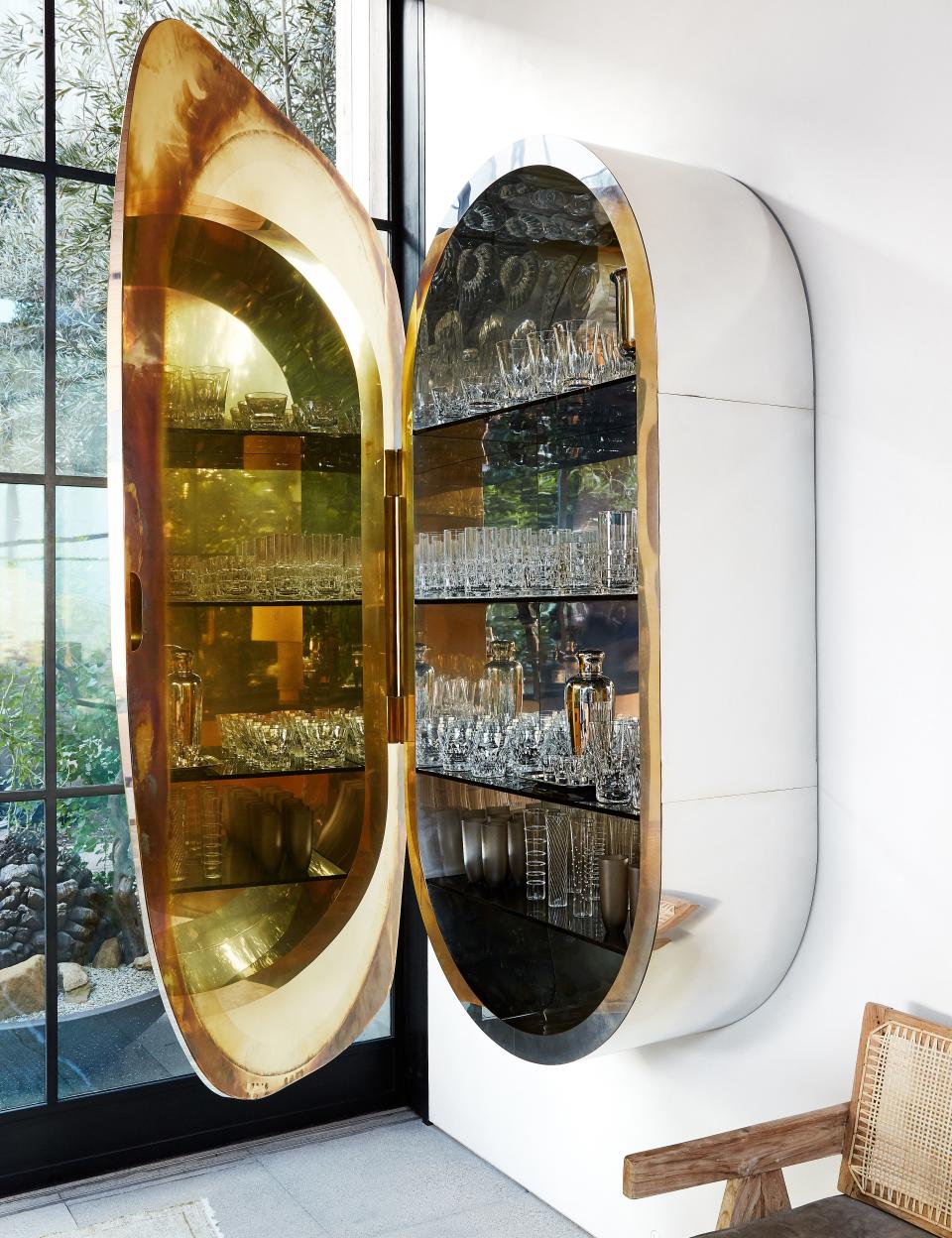 A wall cabinet by Vincenzo de Cotiis stores glassware.